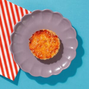 One of our Caramelised Peach and Coconut Tarts on a plate ready for serving to a coffee shop customer.