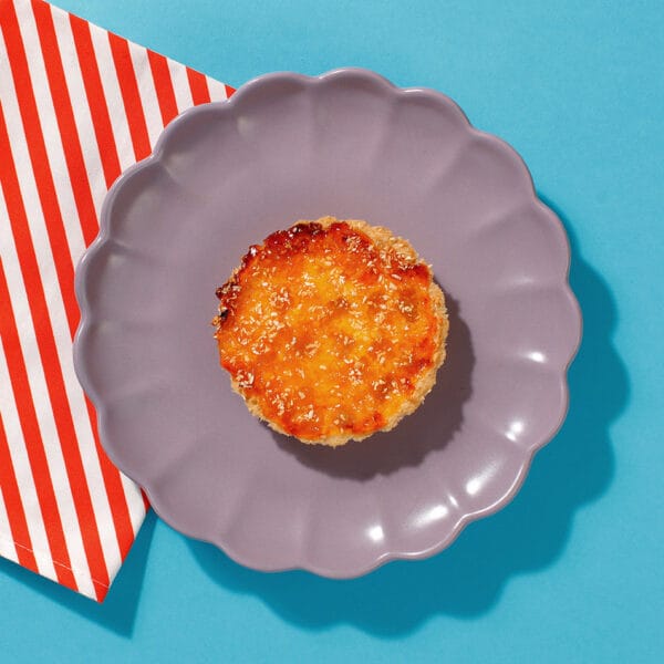 One of our Caramelised Peach and Coconut Tarts on a plate ready for serving to a coffee shop customer.