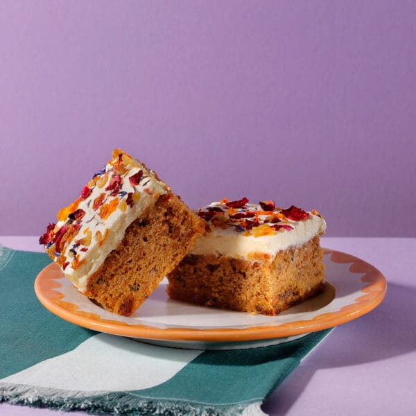 Two slices of our very moreish Carrot Cake Traycakes on a decorative plate.