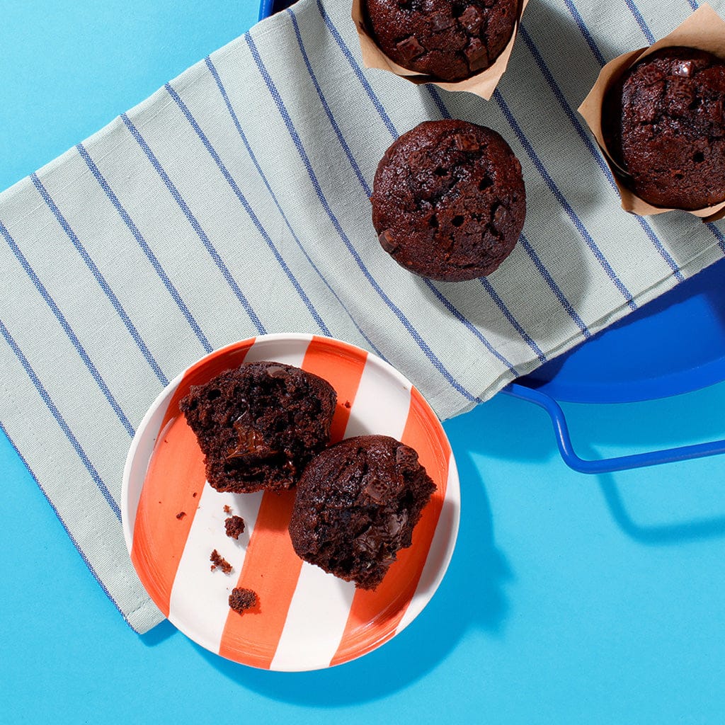 An overhead view of two of our Chocolate Muffins on a plate.