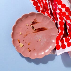An empty plate of our Mini Choco-Hazelnut Beignets except for some crumbs remaining.