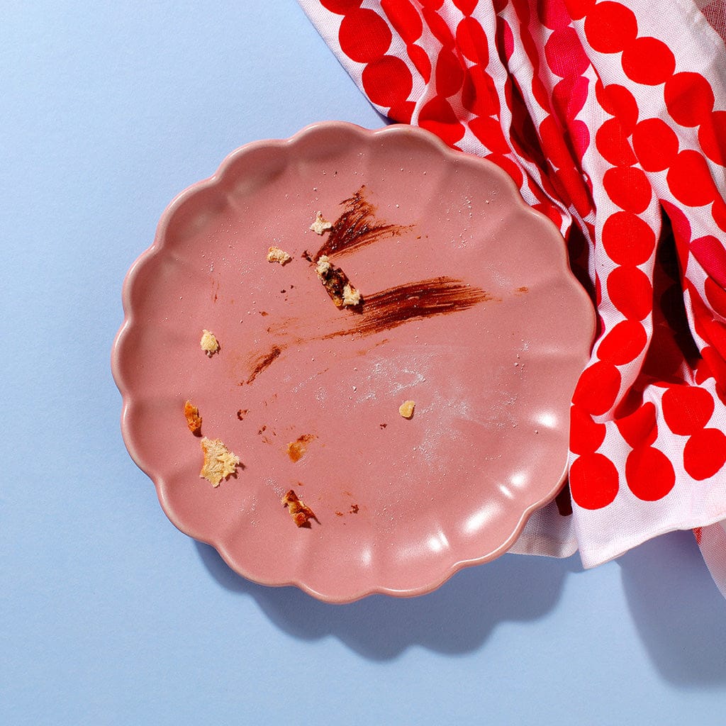 An empty plate of our Mini Choco-Hazelnut Beignets except for some crumbs remaining.