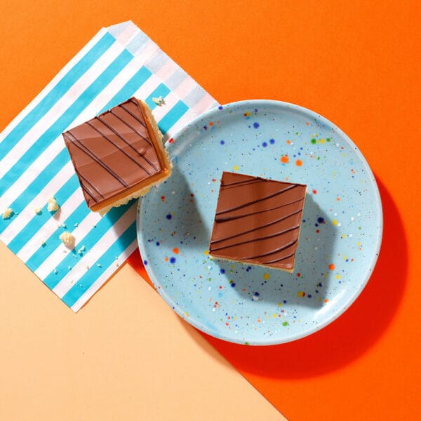 Close-up of The Millionaire shortbread squares topped with Belgian milk chocolate and dark chocolate drizzle.