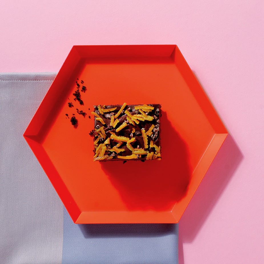 A slice of our vegan chocolate and orange tray cake on a red plate - a serving suggestion for our coffeeshop customers.