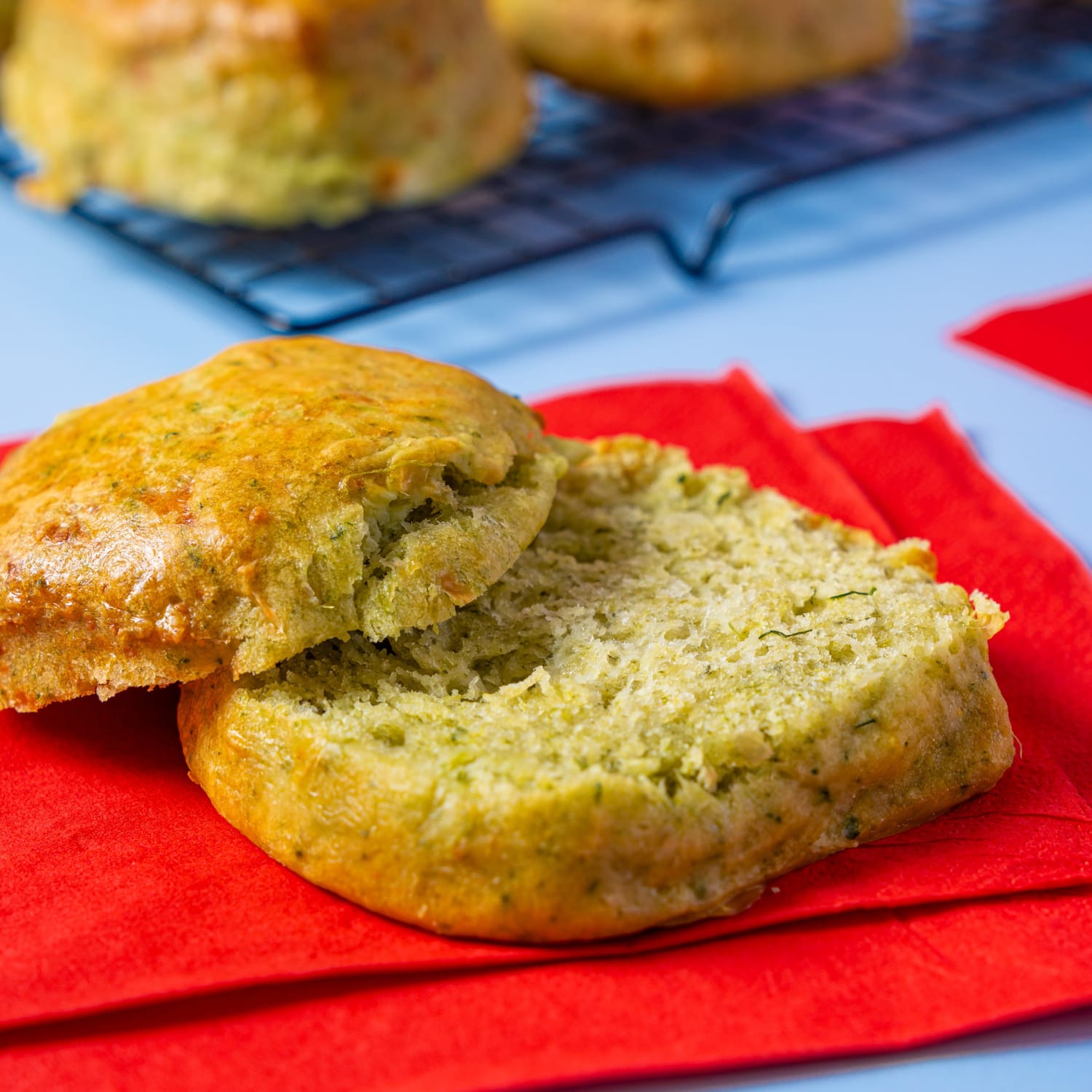 Spinach and Feta Scone cut open on a rack with a red background.