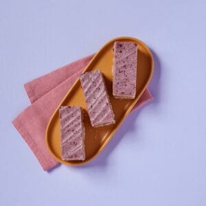 Slices of Blackberry and Mascarpone Traycake on a plate with a pink napkin.