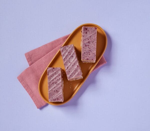 Slices of Blackberry and Mascarpone Traycake on a plate with a pink napkin.