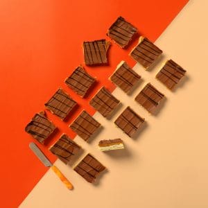 A whole tray of Millionaire shortbread on a peach and orange background.
