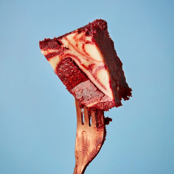 A slice of mouth-watering Red Velvet Brownie from Cake Club held aloft on a fork.