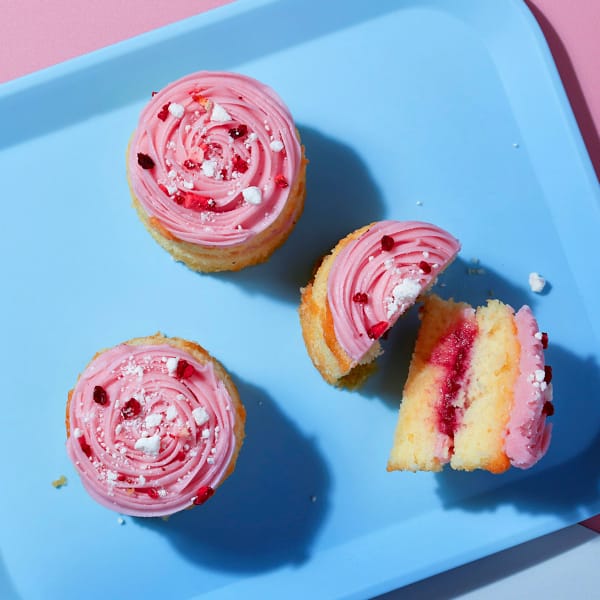 An overhead view of three Eaton Mess Mini Cakes from Cake Club on a blue plate.